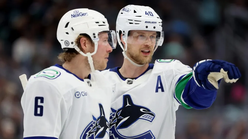Brock Boeser #6 and Elias Pettersson #40 of the Vancouver Canucks talk during an NHL game. (Photo by Steph Chambers/Getty Images)