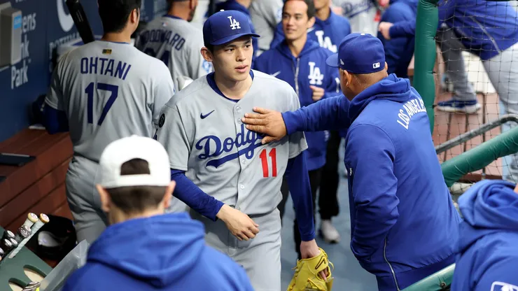 Los Angeles Dodgers manager Dave Roberts taps Roki Sasaki #11 on the chest.