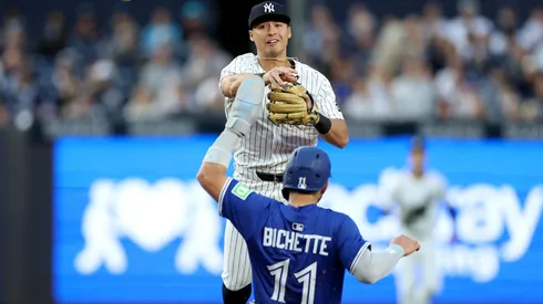 Anthony Volpe #11 of the New York Yankees turns the double play as Bo Bichette #11 of the Toronto Blue Jays.
