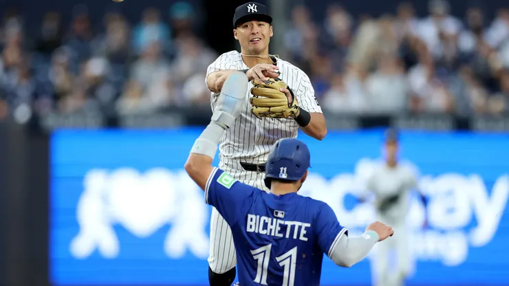 Anthony Volpe #11 of the New York Yankees turns the double play as Bo Bichette #11 of the Toronto Blue Jays.