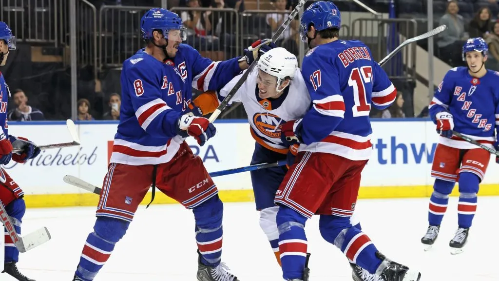 J.T. Miller #8 and Will Borgen #17 of the Rangers combine to check Matthew Maggio #71 of the Islanders. (Photo by Bruce Bennett/Getty Images)