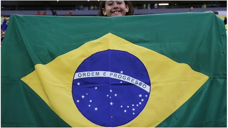 A young fan of Brazil cheers with the Brazilian flag