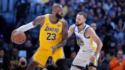 LeBron James #23 of the Los Angeles Lakers controls the ball against Stephen Curry #30.