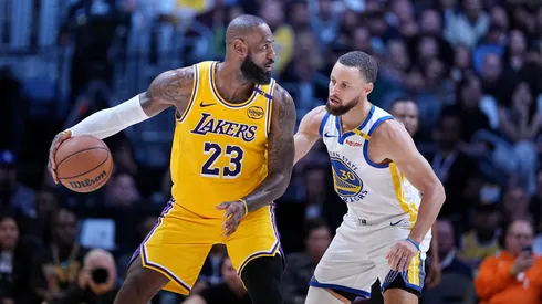 LeBron James #23 of the Los Angeles Lakers controls the ball against Stephen Curry #30.