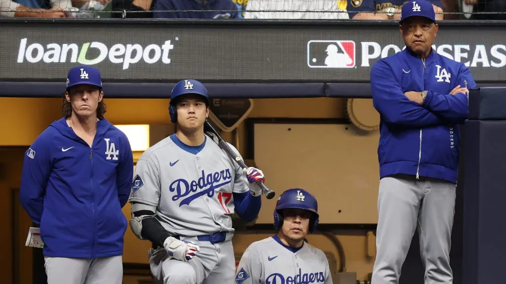 Shohei Ohtani #17 and manager Dave Roberts of the Dodgers look on from the dugout during the ninth inning against the Brewers. Michael Reaves/Getty Images