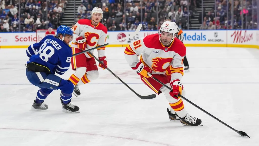 Nazem Kadri of the Flames skates with the puck against William Nylander of the Maple Leafs. Chris Tanouye/Getty Images