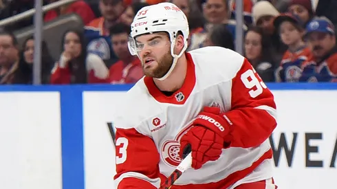 Alex DeBrincat #93 of the Detroit Red Wings makes a pass under pressure.