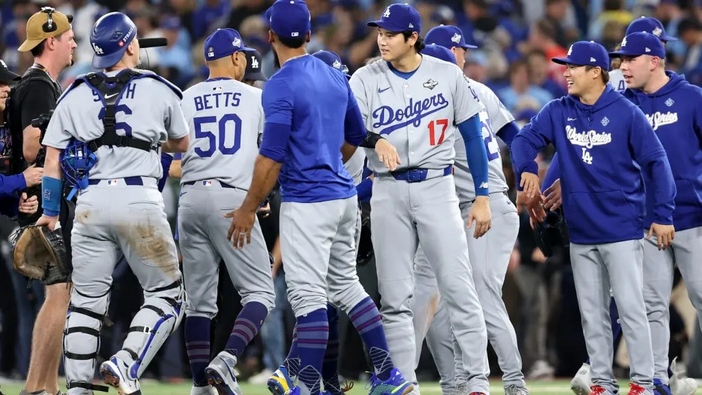 Mookie Betts #50 and Shohei Ohtani #17 of the Dodgers celebrate with teammates after defeating the Blue Jays 3-1. Emilee Chinn/Getty Images