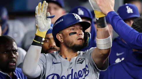 Miguel Rojas #72 of the Los Angeles Dodgers celebrates with teammates in the dugout after hitting a home run.
