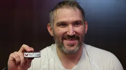 Alex Ovechkin #8 of the Washington Capitals poses with the puck of his 900th career NHL goal.