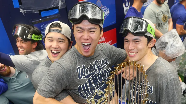 Shohei Ohtani #17, Yoshinobu Yamamoto #18, and Roki Sasaki #11 of the Los Angeles Dodgers celebrate.
