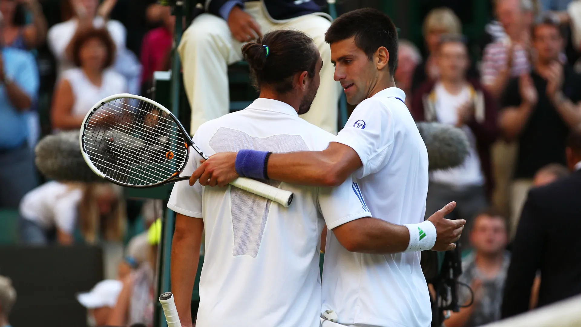 Novak Djokovic shakes hands with Marcos Baghdatis after a Wimbledon game. (Getty Images)