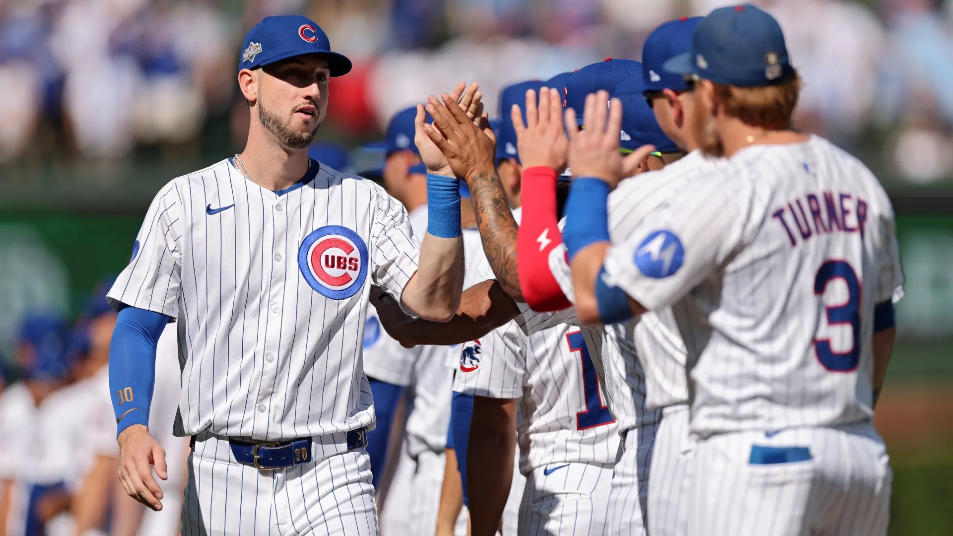 Kyle Tucker #30 of the Cubs greats teammates ahead of game one of the National League Wild Card Series. Michael Reaves/Getty Images