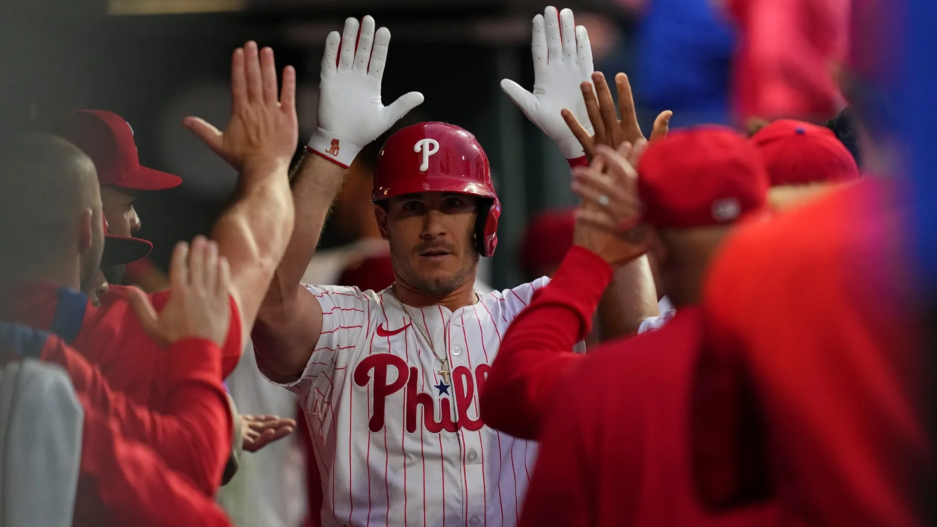 J.T. Realmuto #10 of the Philadelphia Phillies high fives teammates in the dugout. Mitchell Leff/Getty Images