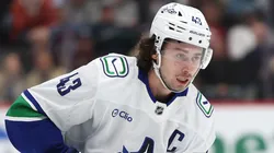 Quinn Hughes #43 with the Canucks controls the puck.