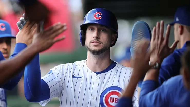 Kyle Tucker #30 with the Cubs high-fives teammates in the dugout.