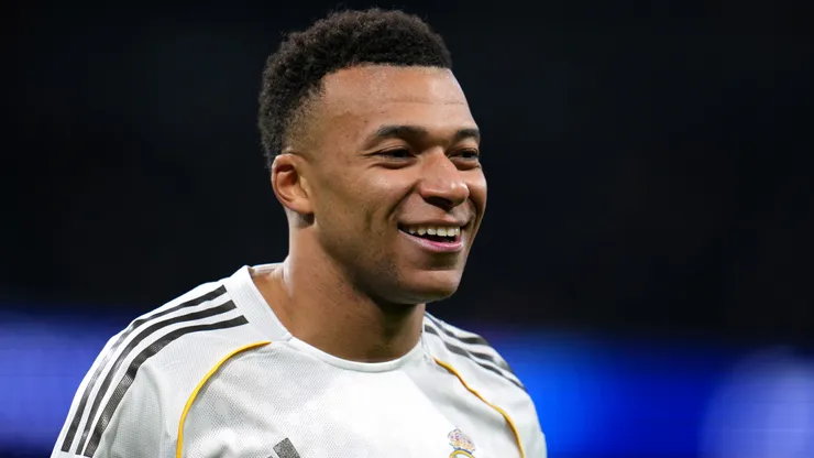 Kylian Mbappe smiles during a Champions League game.