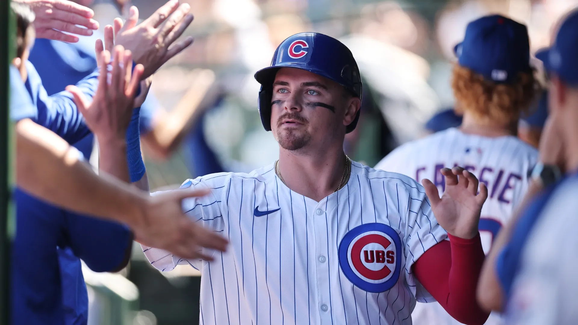 Reese McGuire #20 of the Chicago Cubs high fives teammates after scoring a run. Michael Reaves/Getty Images