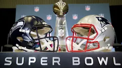 The Vince Lombardi Trophy is framed by the Seattle Seahawks and New England Patriots helmets in 2026.