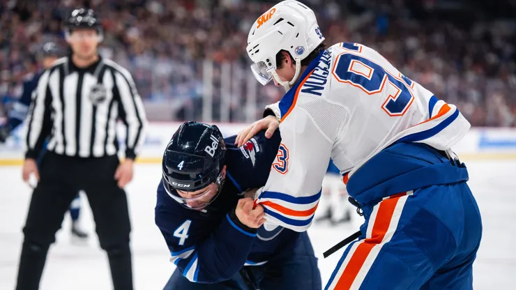 Ryan Nugent-Hopkins of the Edmonton Oilers fights Neal Pionk of the Winnipeg Jets.