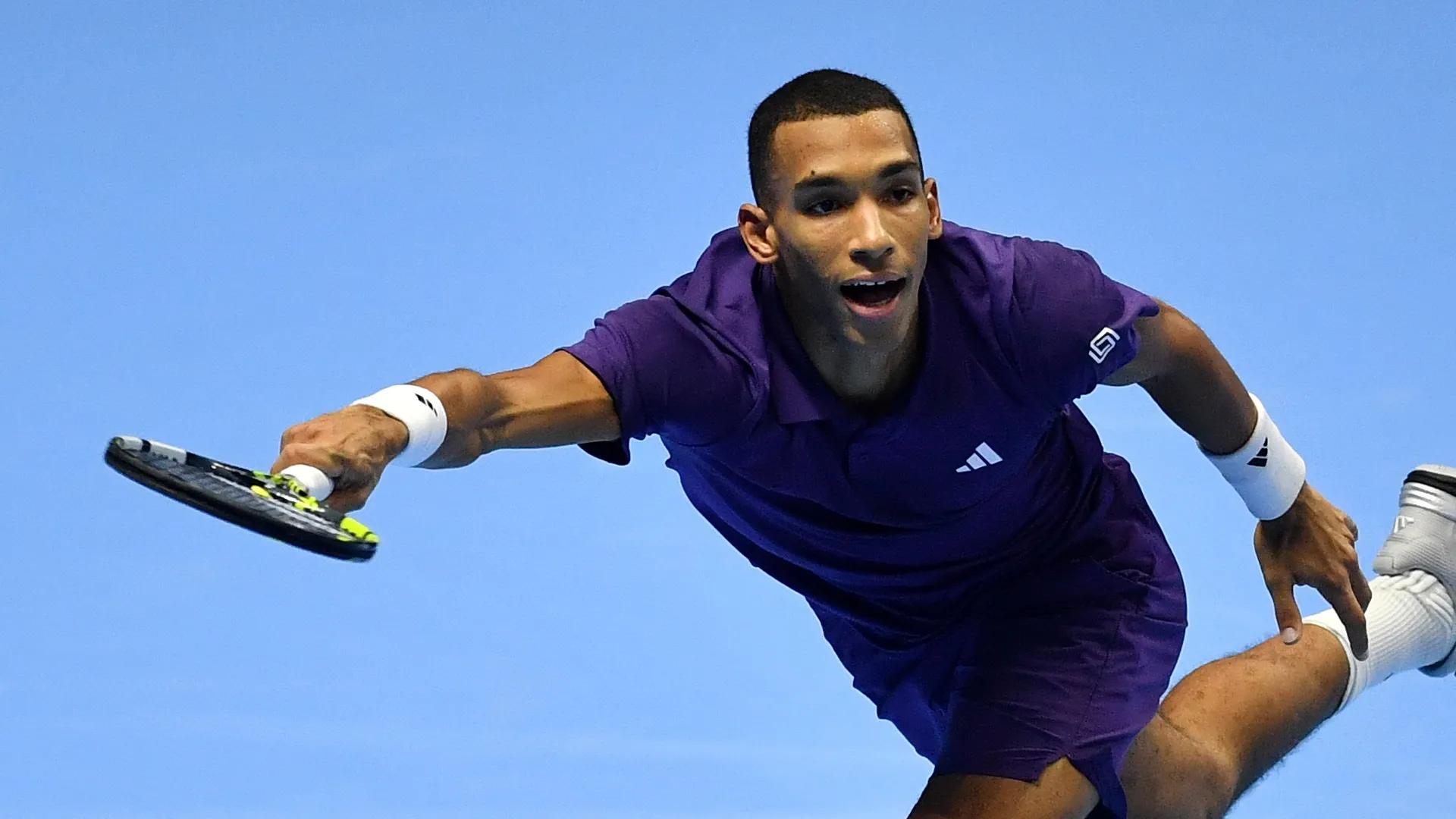 Felix Auger-Aliassime trying to reach the ball