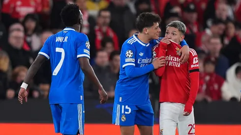 Gianluca Prestianni of Benfica covers his mouth while saying something to Vinicius Junior.