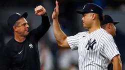 Giancarlo Stanton #27 of the New York Yankees high fives manager Aaron Boone.