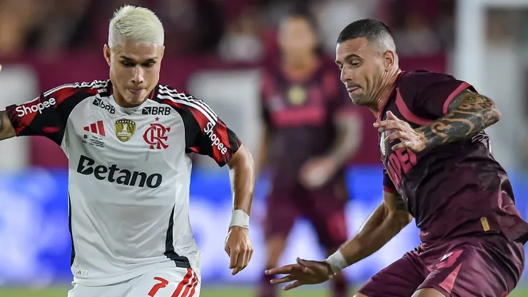 Luiz Araujo of Flamengo controls the ball against Ramiro Carrera of Lanus