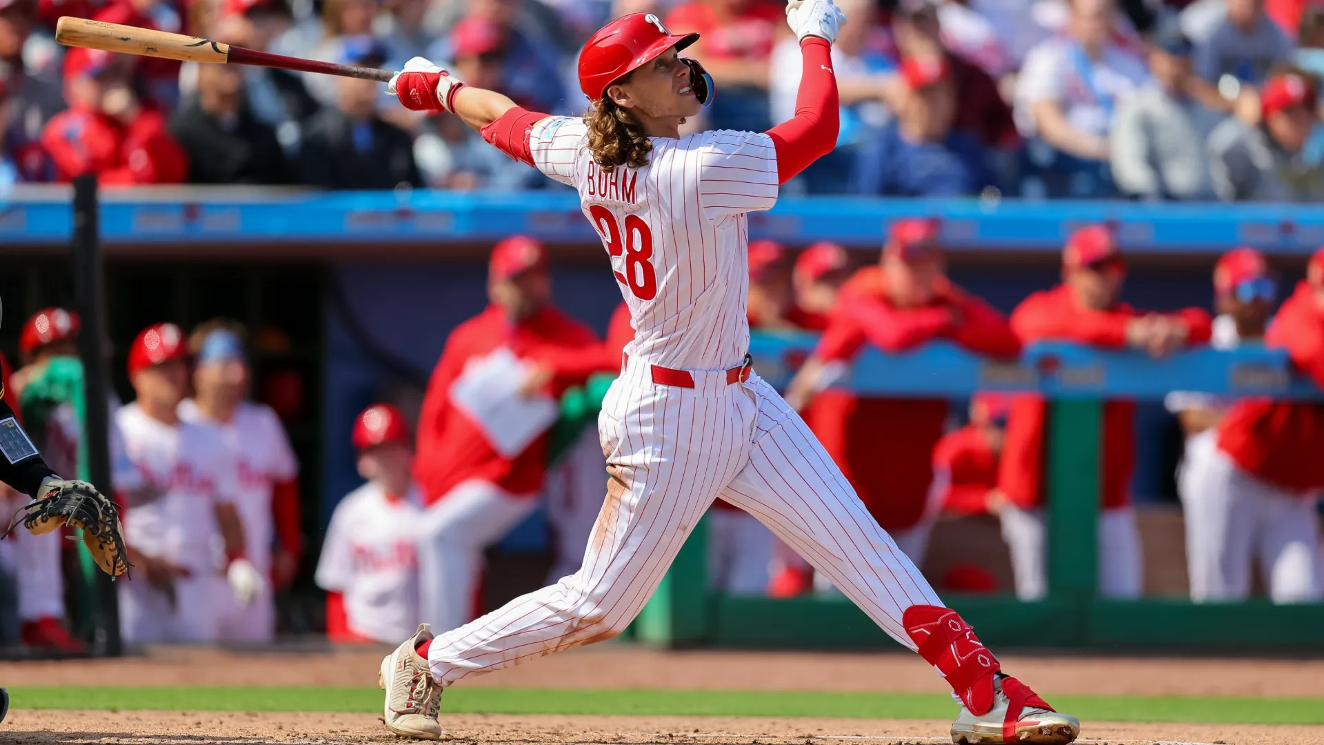 Alec Bohm #28 of the Phillies follows through on a swing. Mike Carlson/Getty Images