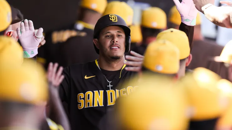 Manny Machado #13 of the San Diego Padres is greeted in the dugout in 2026.
