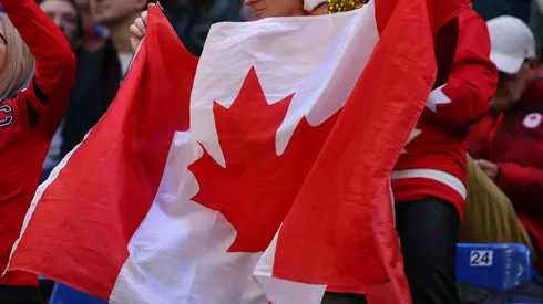 Fans of Team Canada hold up flag