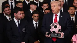 President Donald Trump receives gifts as Lionel Messi looks on.