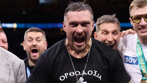 Oleksandr Usyk poses for a photo with the title belts after victory over Daniel Dubois.