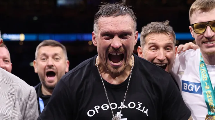 Oleksandr Usyk poses for a photo with the title belts after victory over Daniel Dubois.
