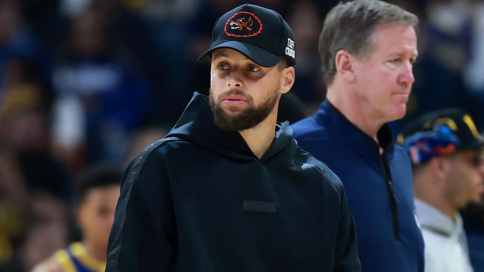 Injured Stephen Curry stands on the side of the court in 2026 (Source: Ezra Shaw/Getty Images)