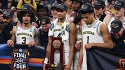 Nimari Burnett #4 of the Michigan Wolverines poses with teammates with the Midwest Regional Championship trophy.