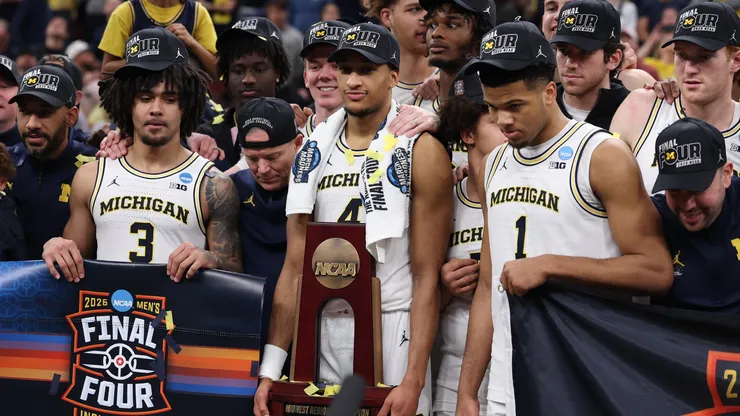 Nimari Burnett #4 of the Michigan Wolverines poses with teammates with the Midwest Regional Championship trophy.