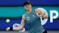 Iga Swiatek of Poland returns a shot.