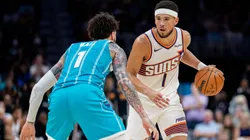 Devin Booker #1 of the Phoenix Suns brings the ball up court while guarded by LaMelo Ball in 2026.