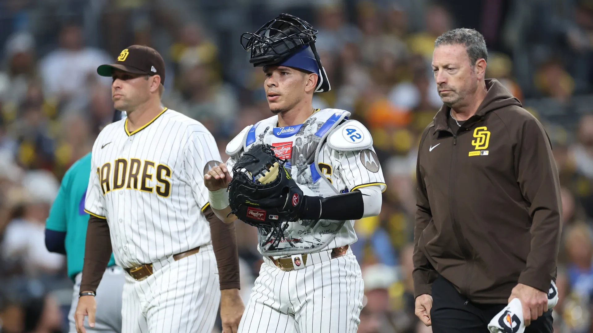 Craig Stammen, and Athletic trainer Mark Rogow tend to Freddy Fermin #54 of the Padres. Sean M. Haffey/Getty Images)