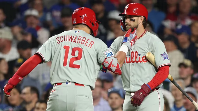 Kyle Schwarber #12 of the Philadelphia Phillies celebrates with Bryce Harper #3. Michael Reaves/Getty Images