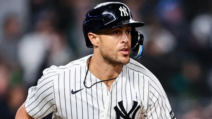 Giancarlo Stanton #27 of the Yankees runs to first after hitting an RBI double.