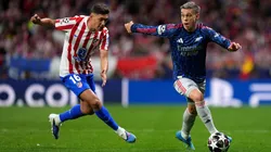 Leandro Trossard runs with the ball while under pressure from Nahuel Molina.