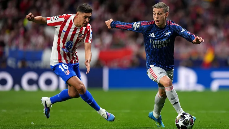 Leandro Trossard runs with the ball while under pressure from Nahuel Molina.