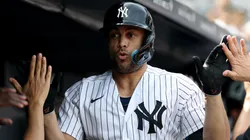 Giancarlo Stanton #27 of the Yankees celebrates in the dugout.