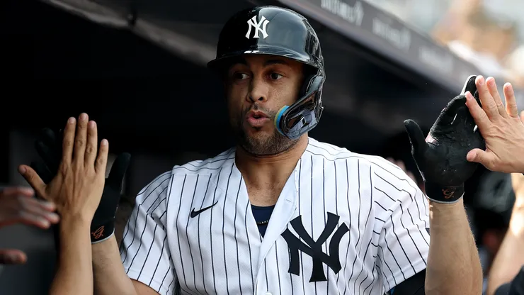 Giancarlo Stanton #27 of the Yankees celebrates in the dugout.