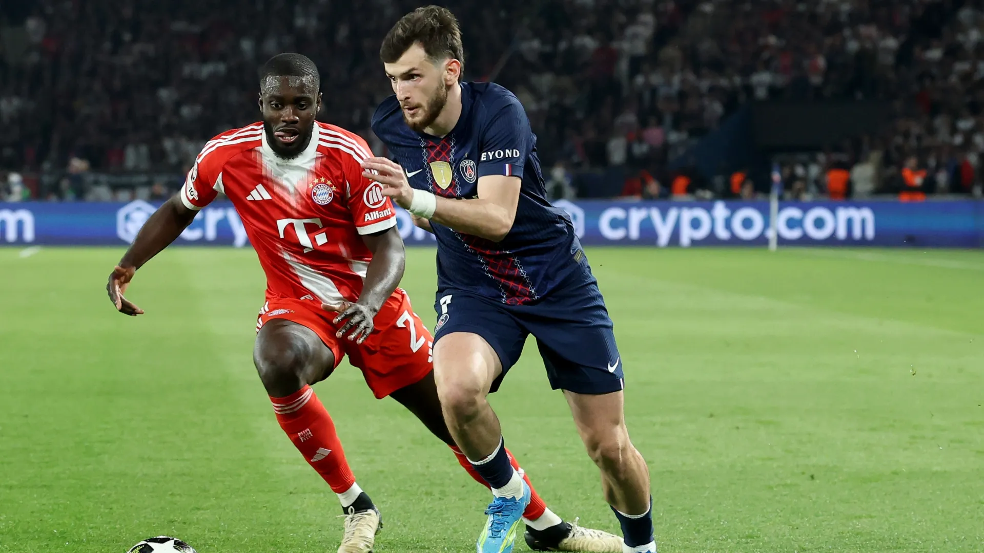 Khvicha Kvaratskhelia of Paris Saint-Germain runs with the ball against Dayot Upamecano of Bayern Munich – Alexander Hassenstein/Getty Images