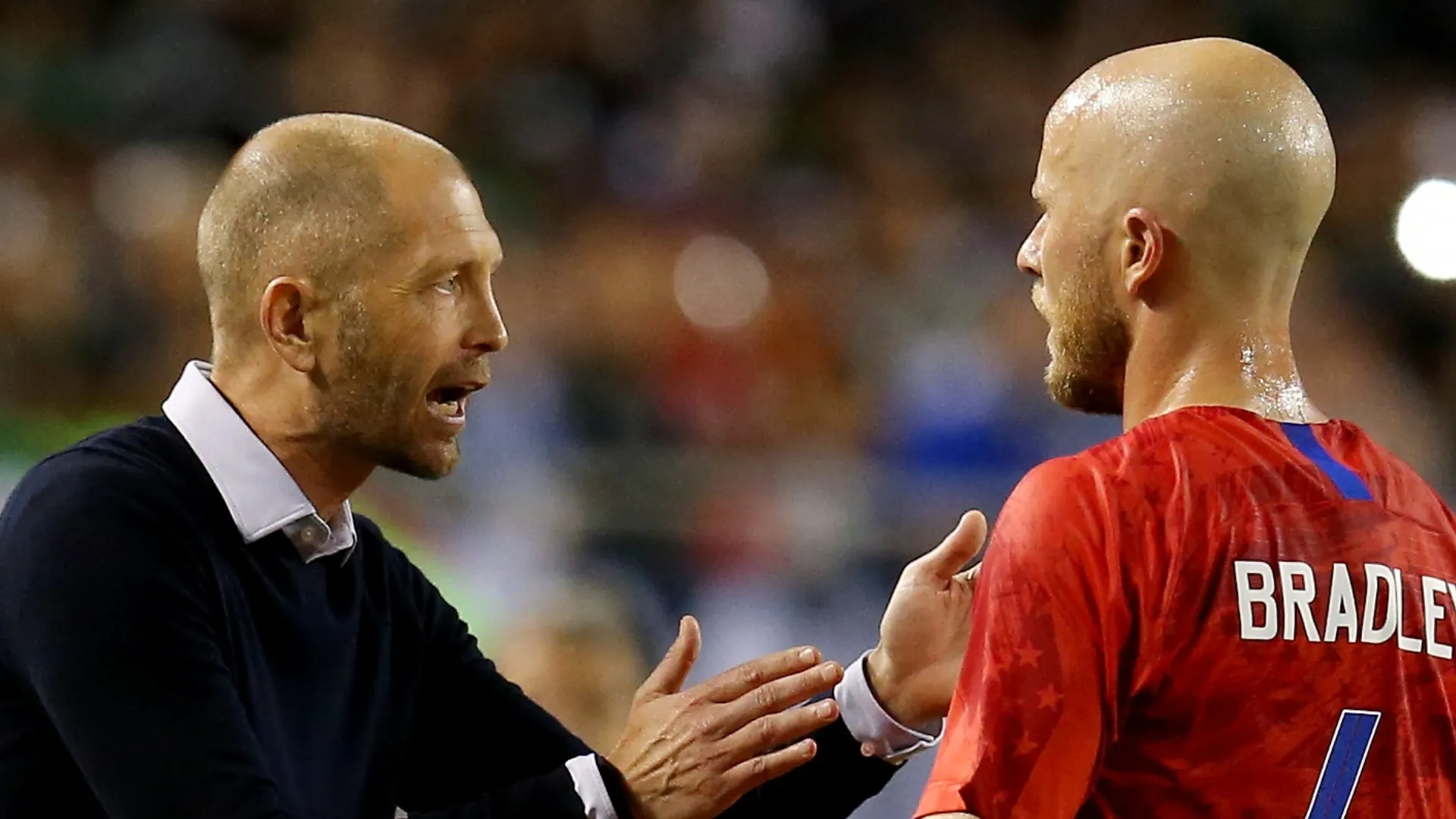 Gregg Berhalter (left) talks to Michael Bradley during a USMNT game.
