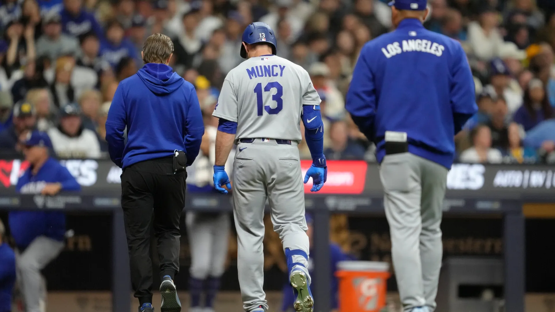 Max Muncy #13 of the Dodgers leaves the game after being hit by a pitch vs the Brewers. Patrick McDermott/Getty Images