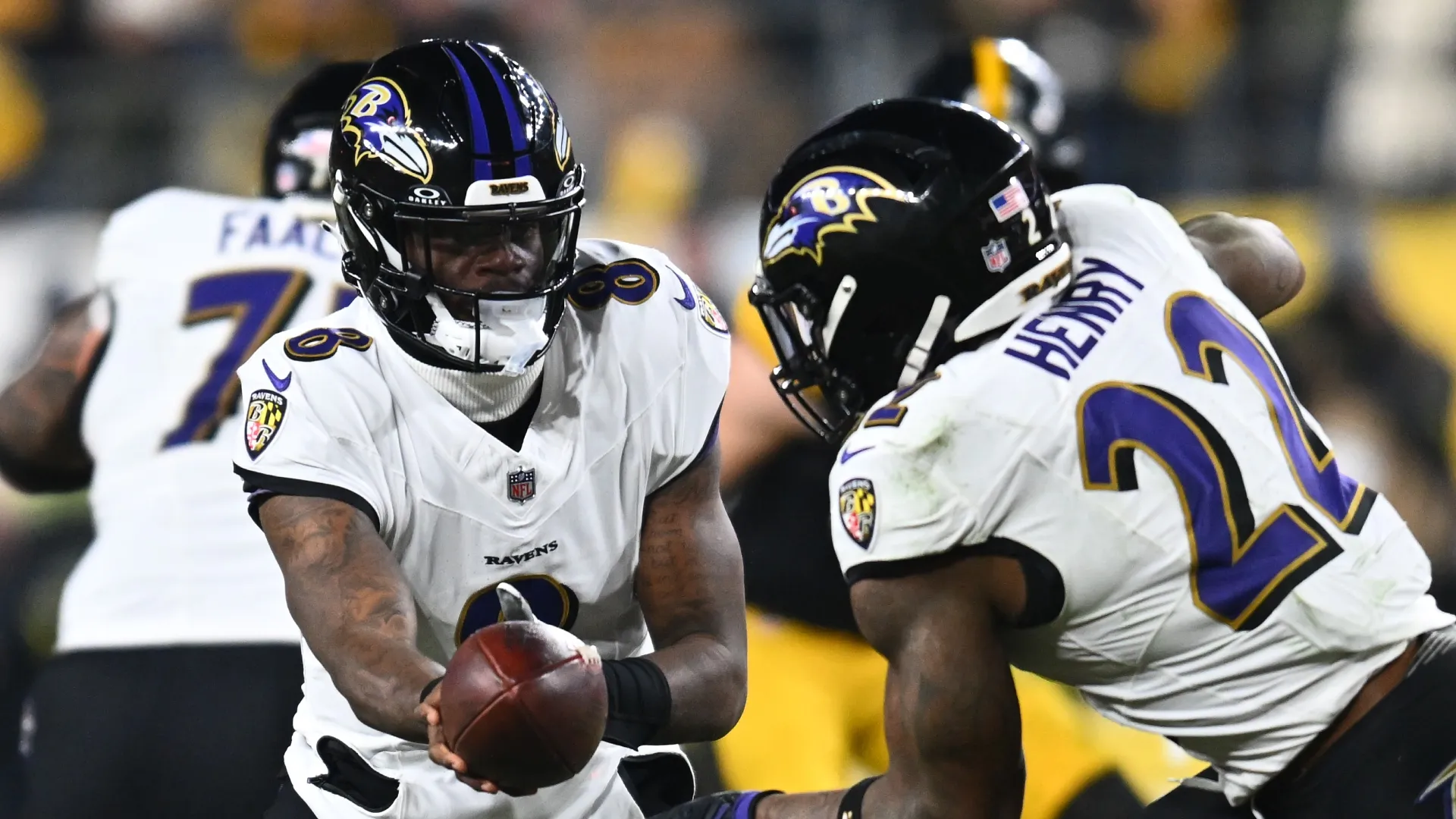 Lamar Jackson handing the ball off to Derrick Henry.